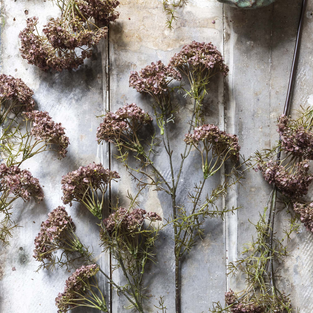 Pink artificial flowers on a textured surface.